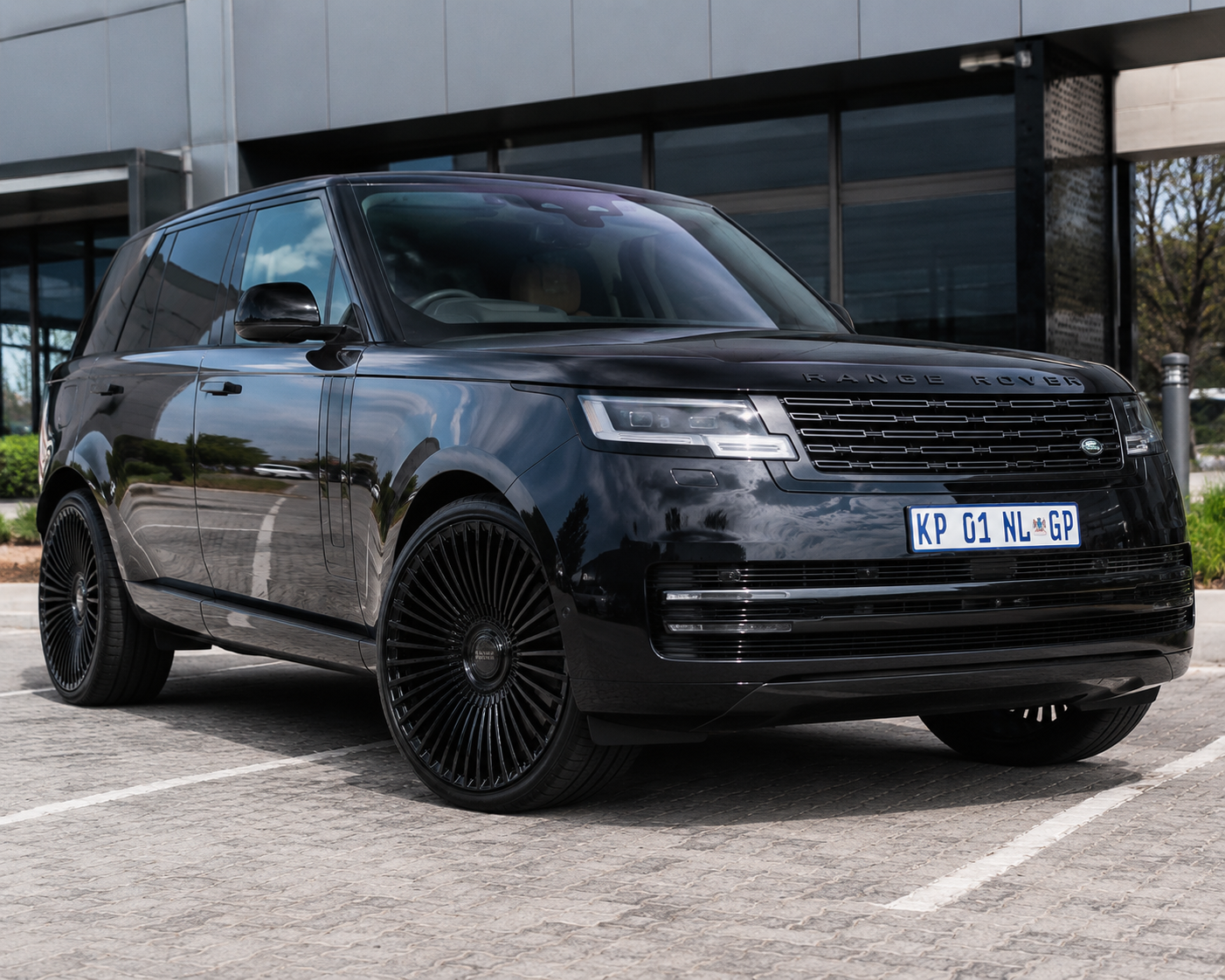Black Range Rover SUV parked outdoors featuring 22-inch gloss black multi-spoke turbine alloy wheels.